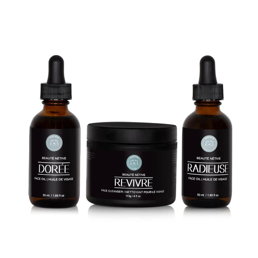 Beauté Nétive Skincare Transformation Trio featuring Dorée face oil, Revivre face cleanser, and Radieuse face oil in amber glass bottles with black labels and droppers, displayed on a white background.